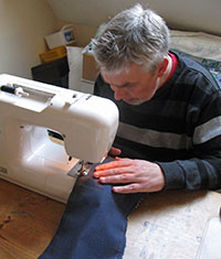 image of a man using a sewing machine