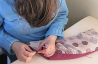 image of hand sewing 